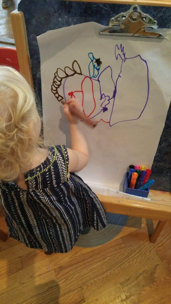 A Montessori toddler student working with art materials in the classroom